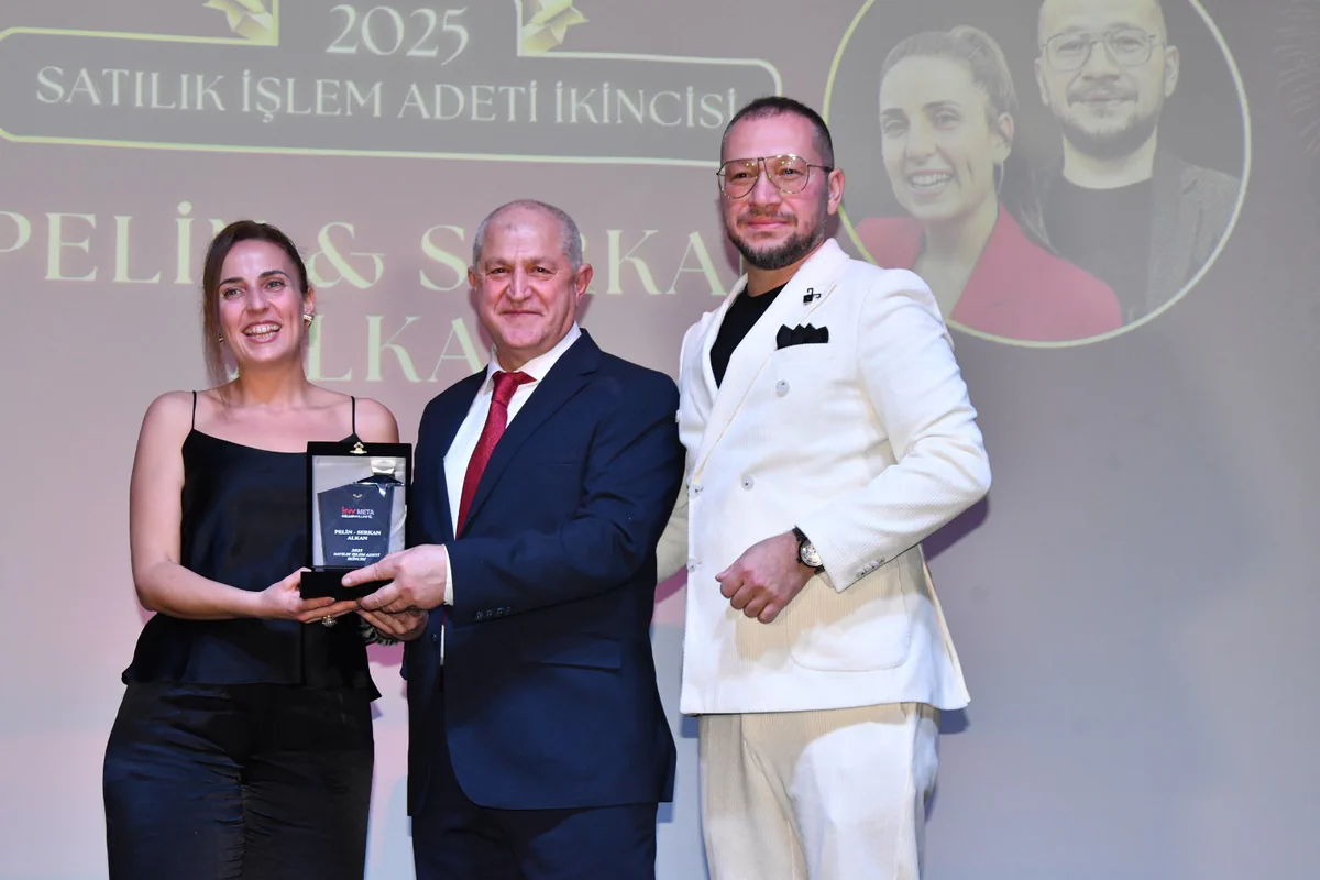 Pelin ve Serkan Alkan ödüllerini sahnede alırken; arkadaki ekranda 2025 satılık işlem adedi ikinciliği yazıyor